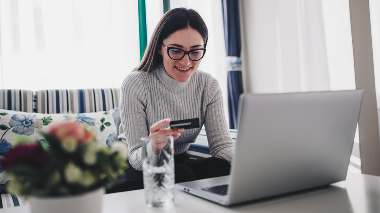 person laptop holding credit card