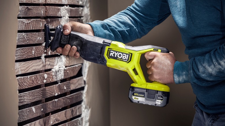 Man cutting through wall