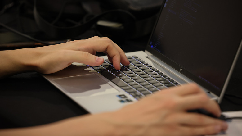 Hands on a laptop keyboard