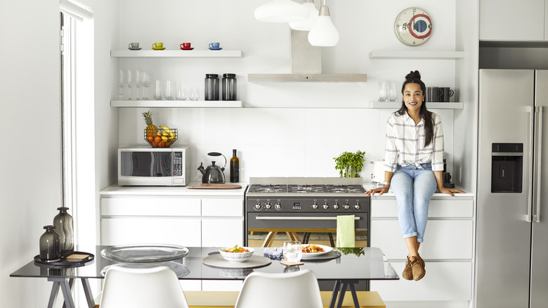 woman sitting on kitchen countertop