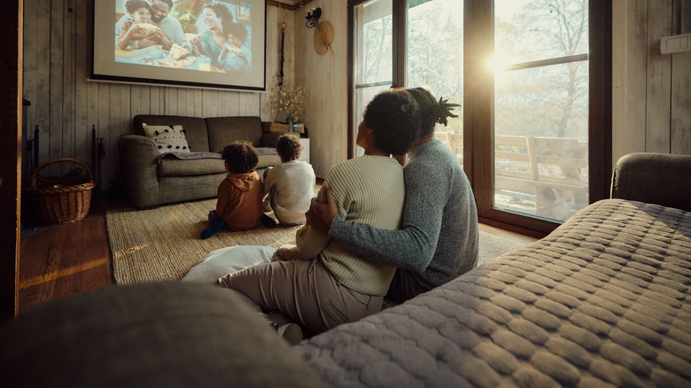 family watching on a projector screen